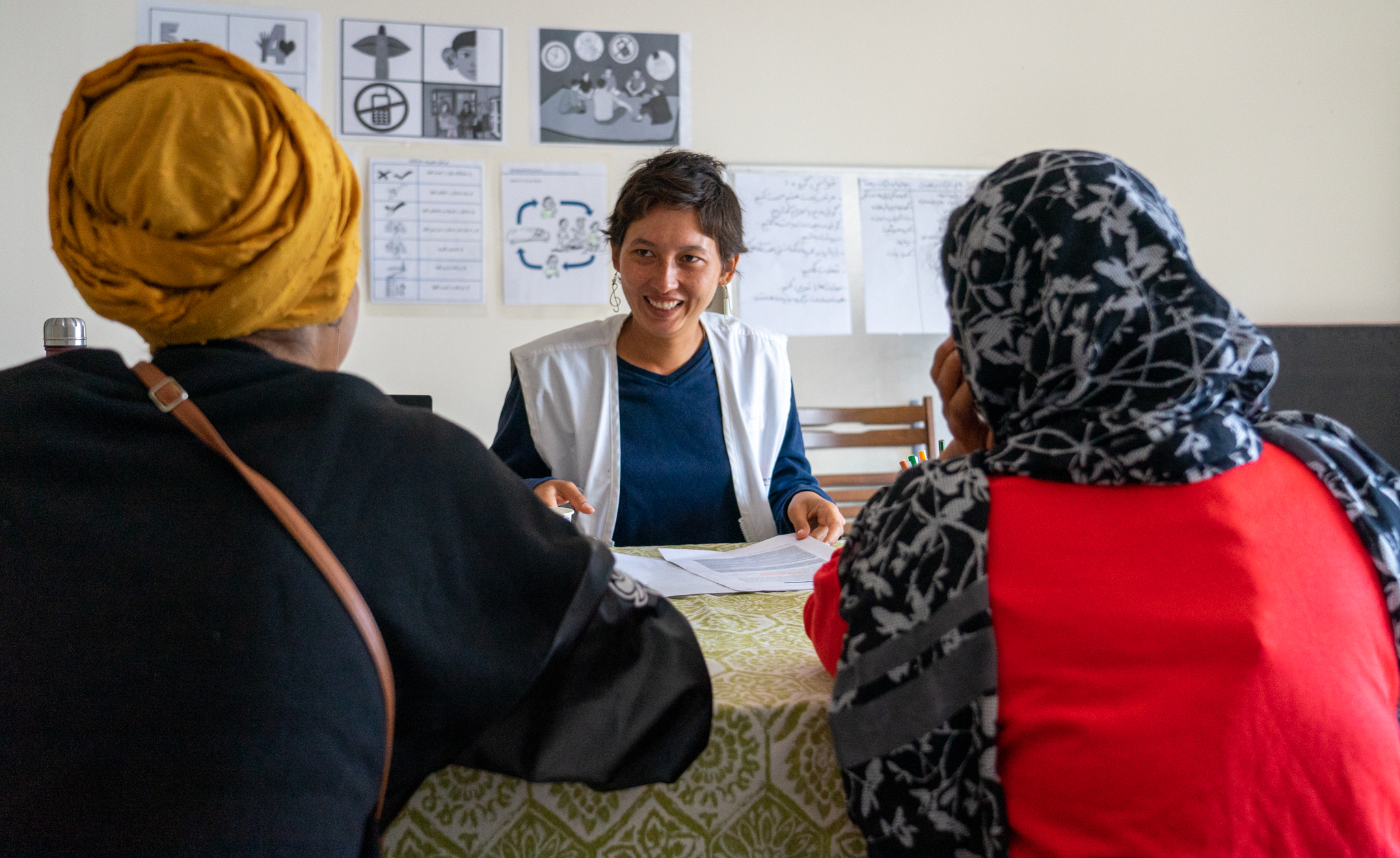 Medium shot of an MSF health promoter speaking to two women during a health promotion consultation 