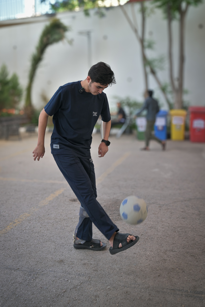 Iyad plays football in the playground of the MSF reconstructive surgery hospital in Amman, Jordan.