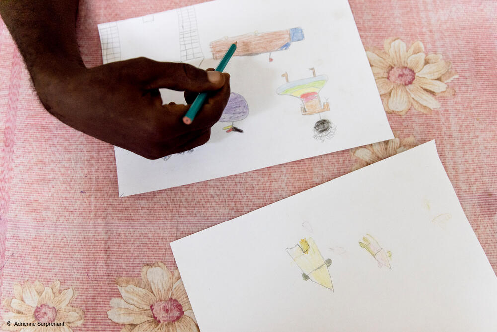msb32349_medium.jpeg Aimé Césaire Likosso, mental health advisor with the MSF Tongolo project in Bangui, CAR, points out details in drawings made by child sexual assault survivors on 30th November 2020