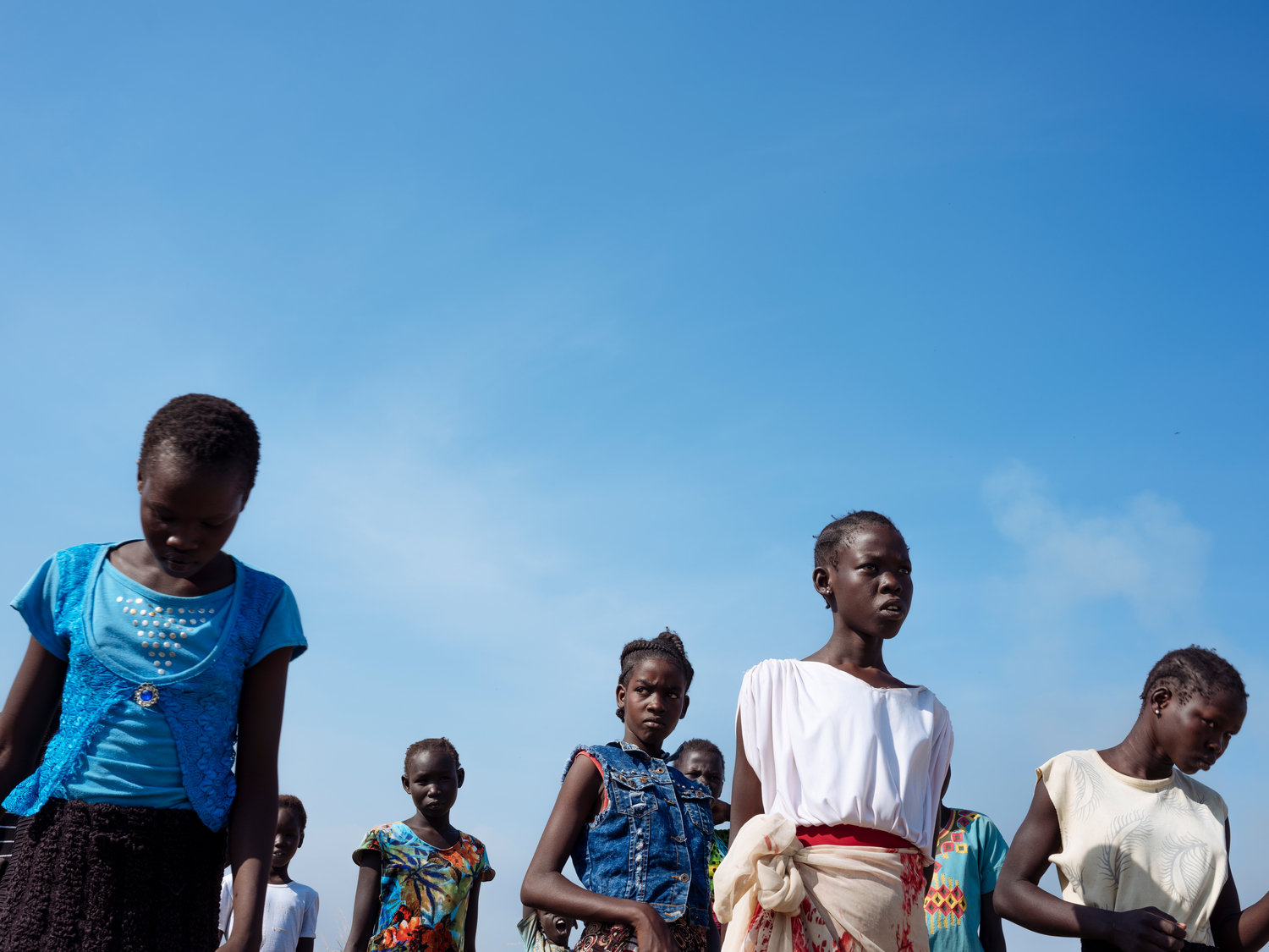 Bentiu, South Sudan, 2018. Children dance and sing near a church in Bentiu PoC (Protection Of Civilians) site.  [Emin Ozmen/Magnum Photos]