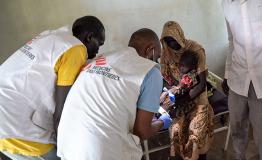 MSF medical team providing treatment for a child affected by malaria.