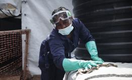 A hygiene worker disinfecting and cleaning the new cholera treatment centre to strengthen the outbreak response in South Kivu.