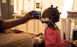 Amna Abderahim (not visible), 21, a Sudanese refugee who fled the 2023 massacres in El Geneina (Sudan), gives water to her daughter Djout Mahamat, 11 months old