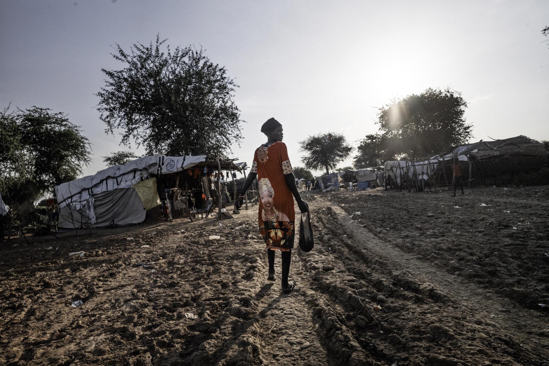 A woman heads for the makeshift market on the outskirts of the Gomgoi IDP camp in Twic, Warrap state, South Sudan