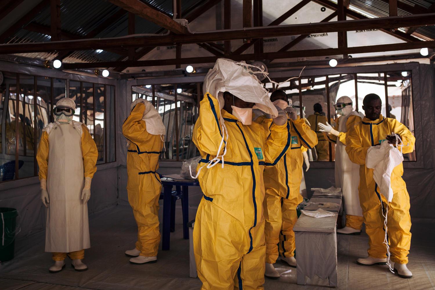 Health workers putting on their personal protective equipment (PPE) before entering in the red zone of the ETC in Butembo, DRC 