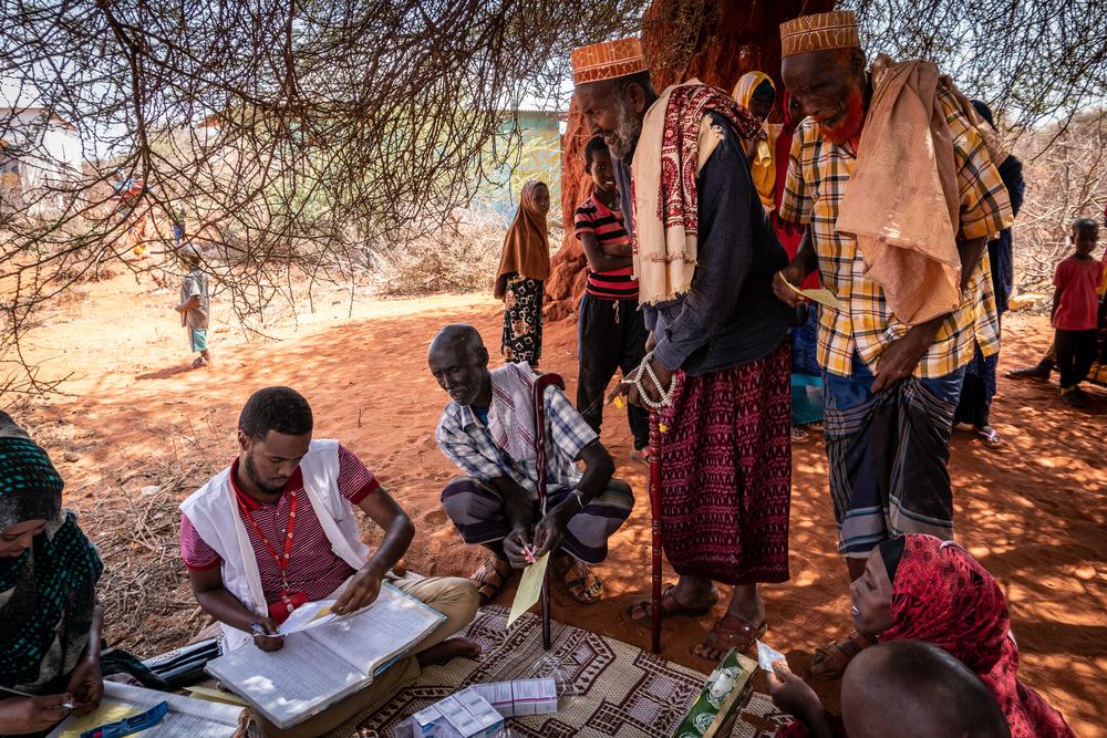 MSF pharmacist Amina Mahamed hands out medication to patients, MSF outreach supervisor Mahad Ali Aden assists her, since it is a very busy day.  [© Susanne Doettling/MSF] 