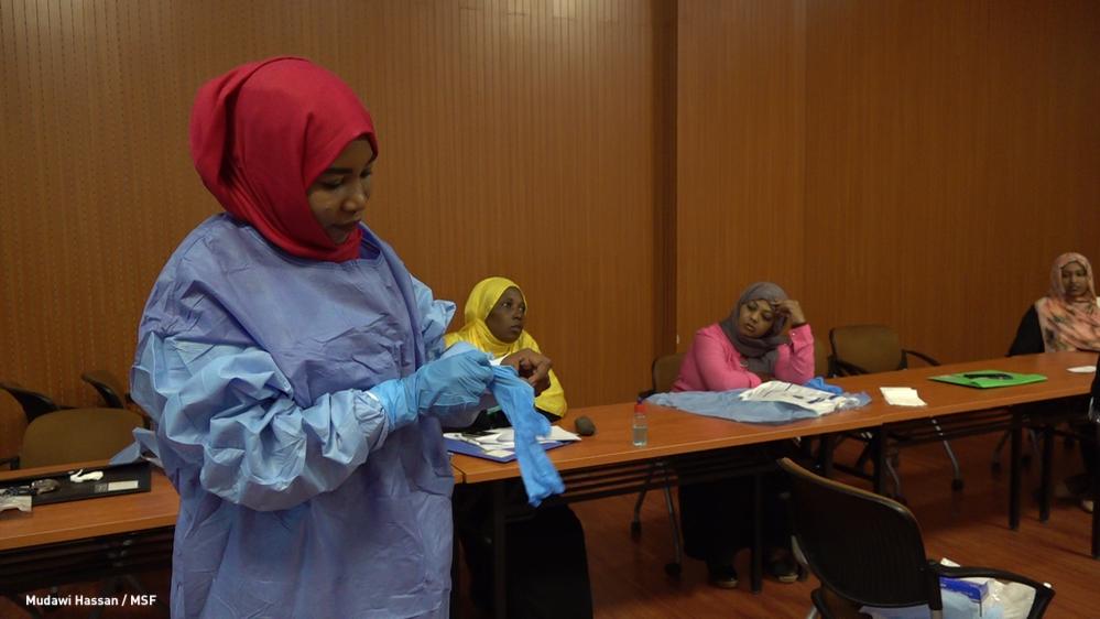 A Sudanese health professional dresses in PPE during a training by MSF (March 2020)