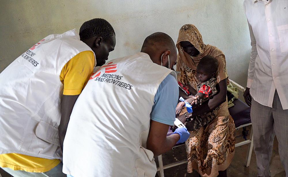MSF medical team providing treatment for a child affected by malaria.