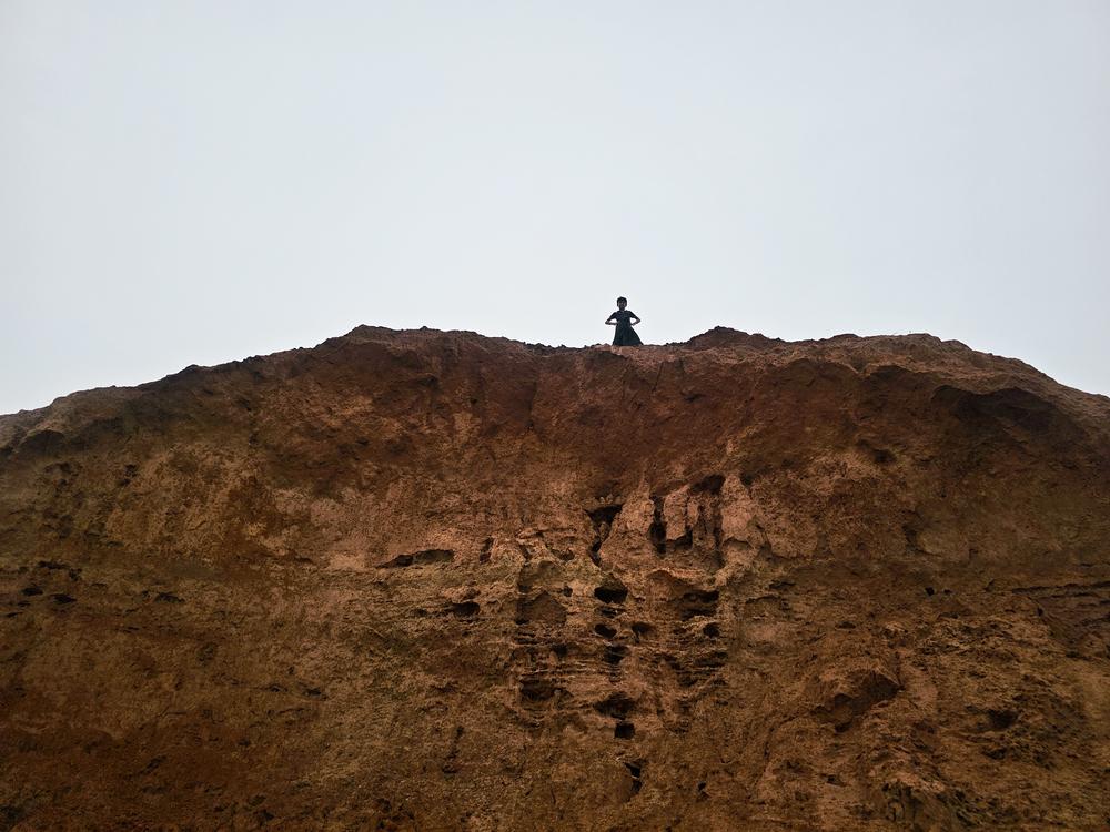 A child overlooks the camps from an eroded hill top, Bangladesh, June 2025.