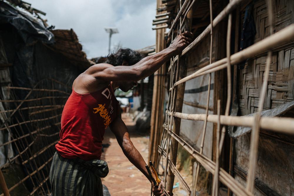 A man repairs his shelter in the Kutapalong camps, Bangladesh, June 2025.