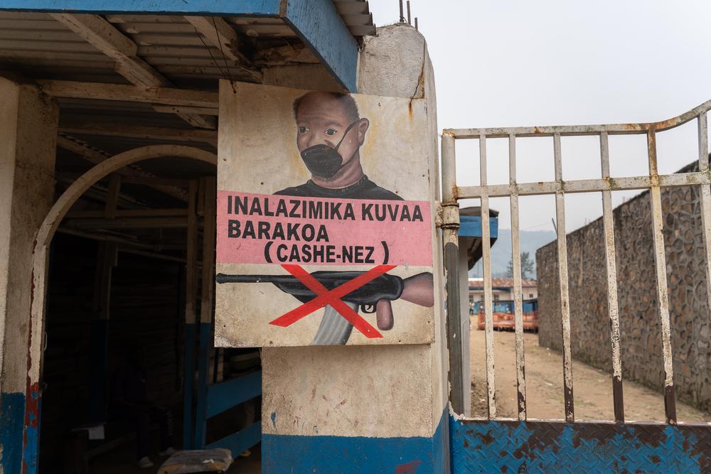 A sign outside the Masisi General Reference Hospital, where MSF provides full support, encourages patients to wear face masks and makes clear that weapons are banned.