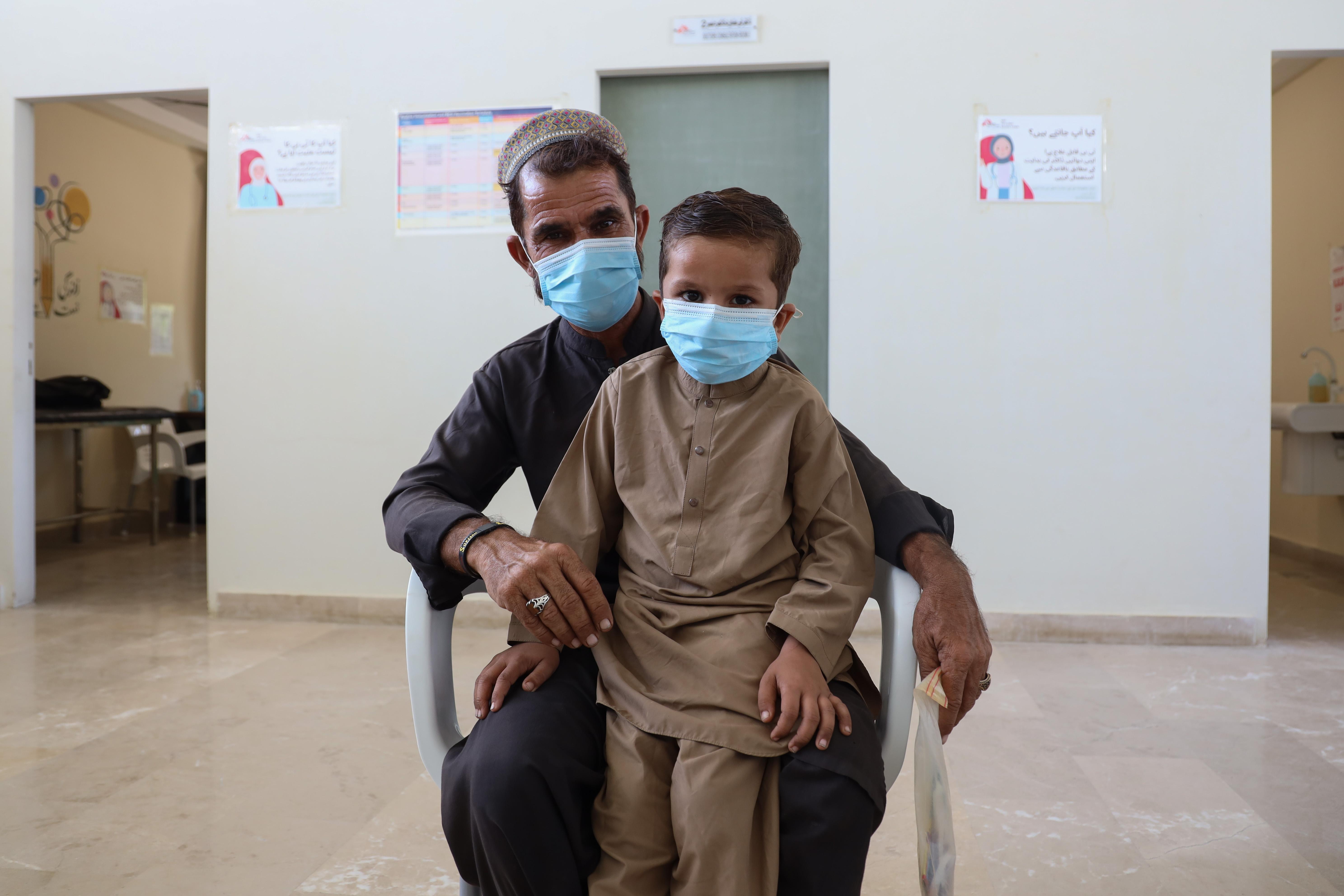 Six-year-old Mustafa and his father Muhammad Rahim are sitting in front of the consultation rooms at the MSF TB clinic in Baldia Town, Karachi, where Rahim shares Mustafa’s recovery story.