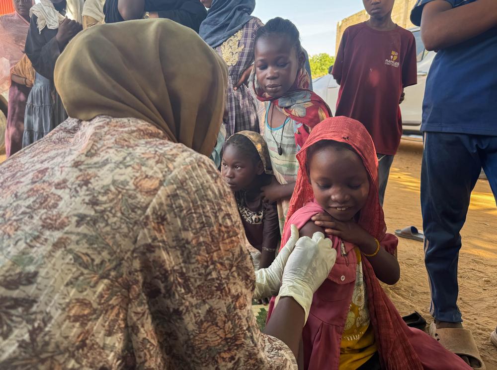 Ten-year-old Reem celebrates with a smile after receiving her measles and rubella vaccine in Alsafa, El Geneina. After showing her younger siblings that 'it only pinches and goes away quickly', Reem stood tall and encouraged her family.