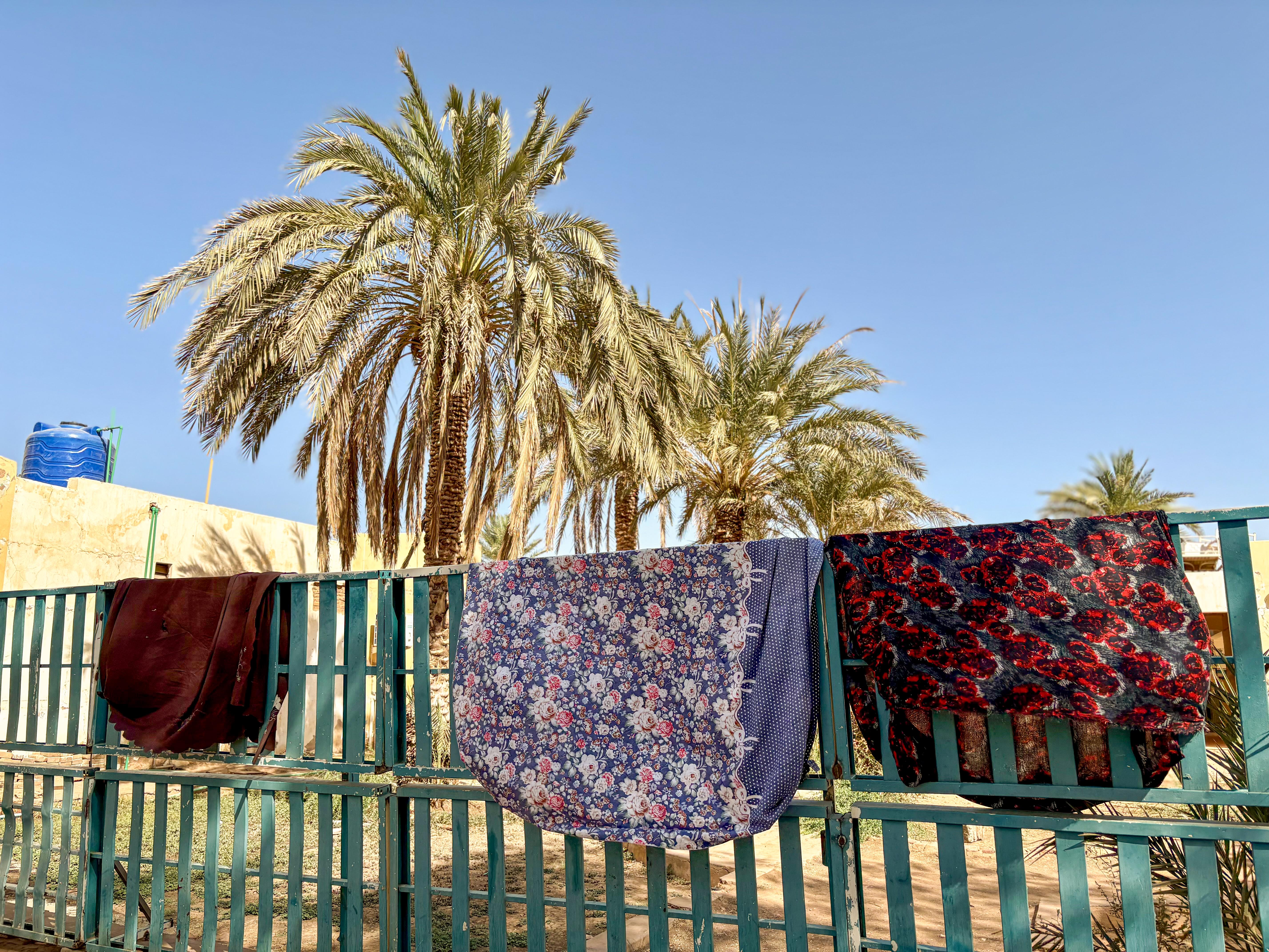 Sheets are drying in the sun in the laundry area at the back of the hospital.